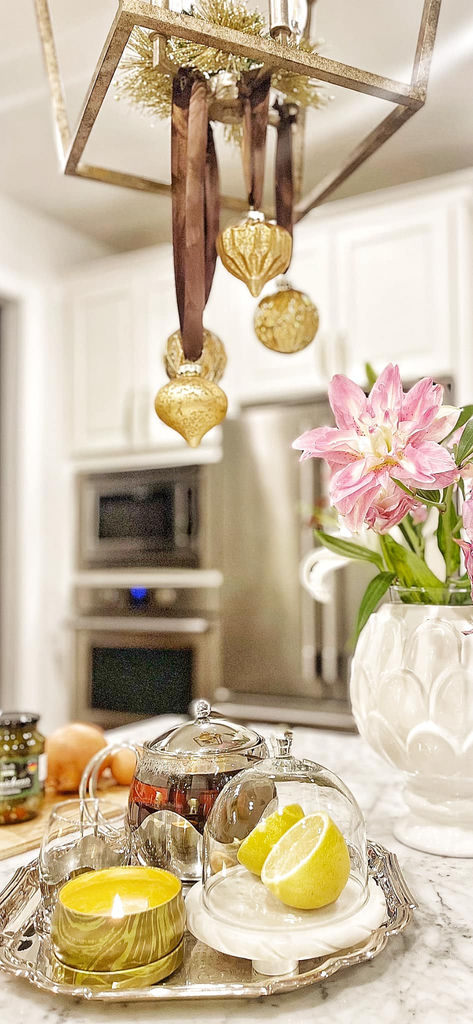 Kitchen styled with gold box chandelier and holiday ornaments — seasonal decor
