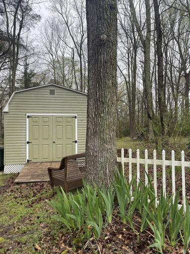 Yard and outbuilding with white picket fence and spring irises — outdoor styling