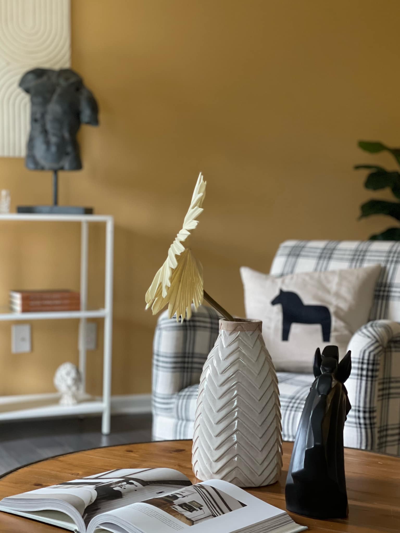 Mustard yellow accent wall with styled vignette — Cosmopolitan Interiors color consultation