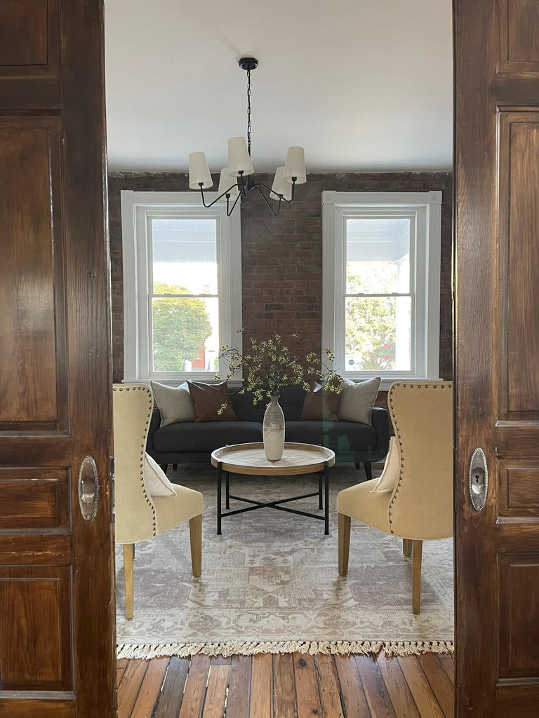 Professionally staged living room viewed through elegant double doors — Cosmopolitan Interiors Richmond