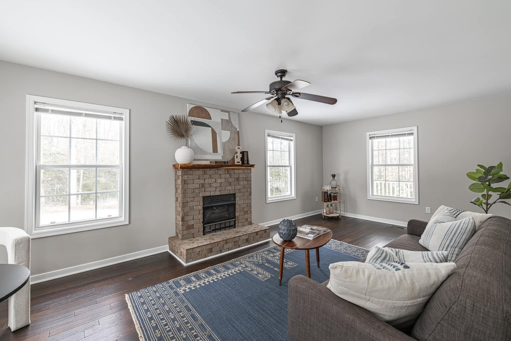 Staged living room with brick fireplace and blue rug — Richmond VA home staging
