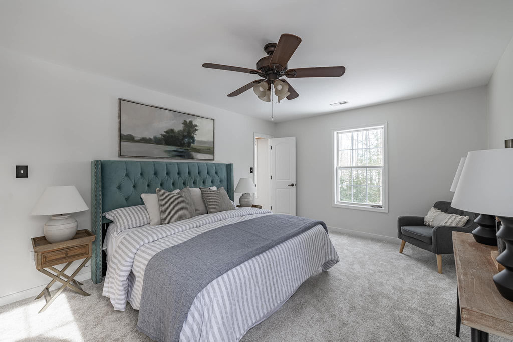 Staged master bedroom with teal upholstered headboard — Cosmopolitan Interiors Richmond